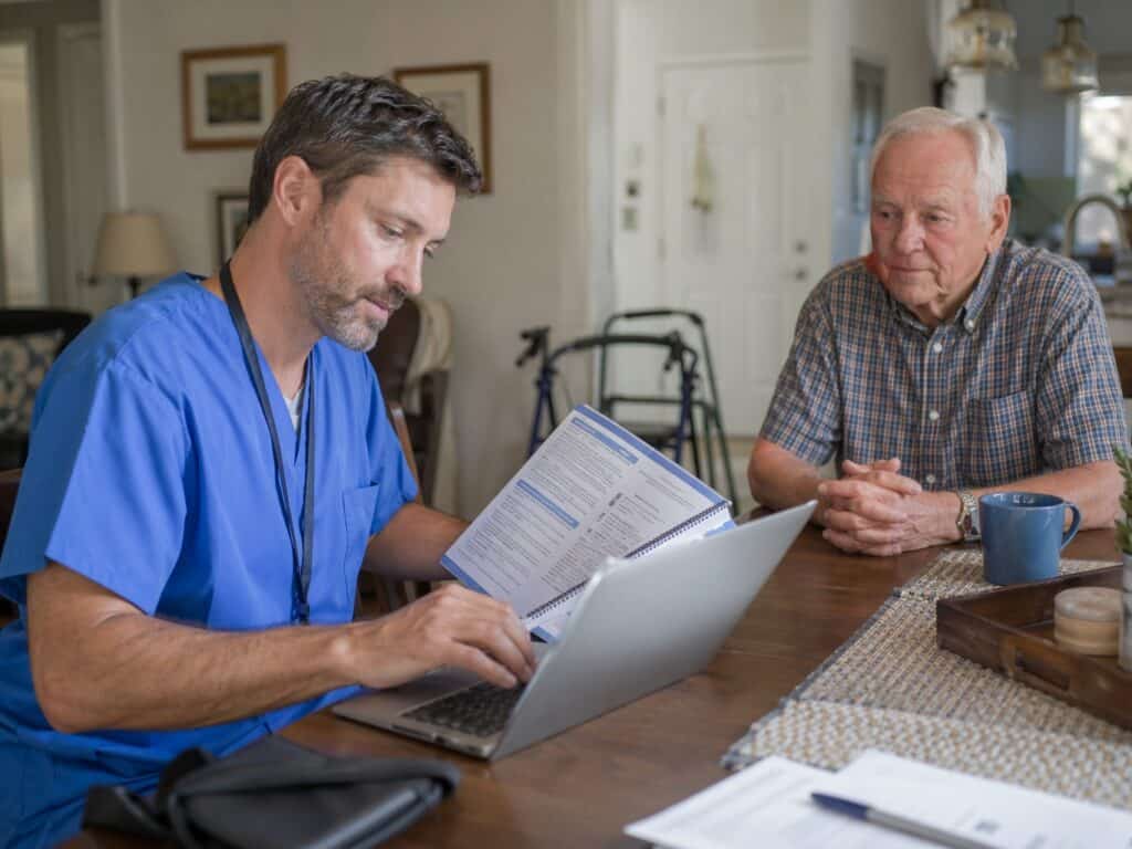 Home health nurse reviewing OASIS-E documentation with patient at home.