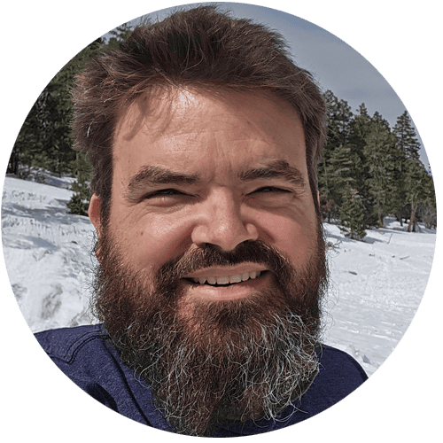 Portrait of Tomas Berry, smiling outdoors in snowy landscape.
