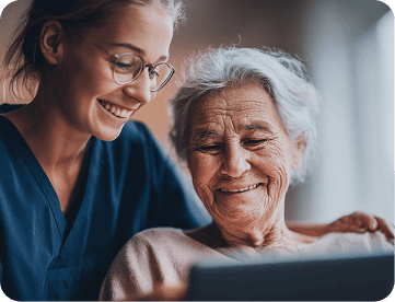 Healthcare professional assisting elderly patient with AI technology in homecare setting.