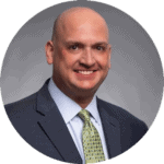 Professional man in a suit smiling for a corporate photo. HCHB