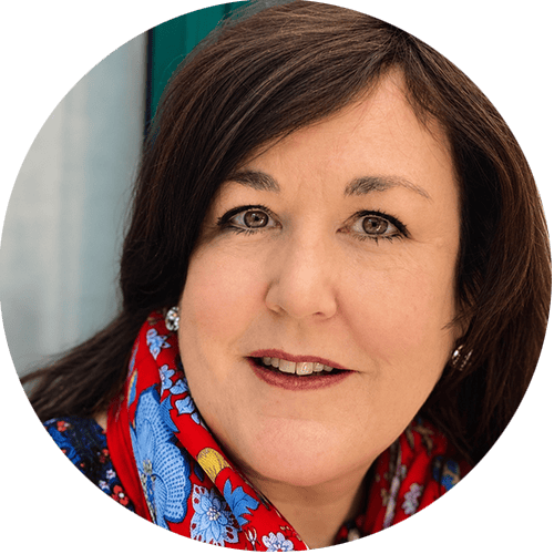 Professional woman with dark hair and colorful scarf smiling for the camera. HCHB